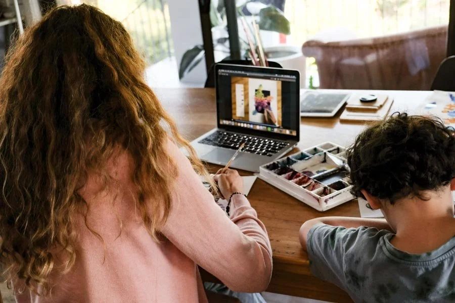 Adult and child painting watercolors during an online art lesson